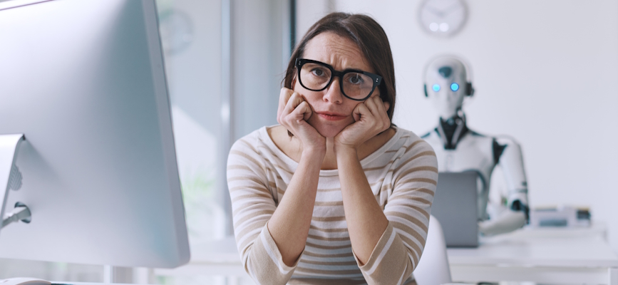 A robot sits behind an unhappy jouralist to show the possibly negative impact of AI in journalism