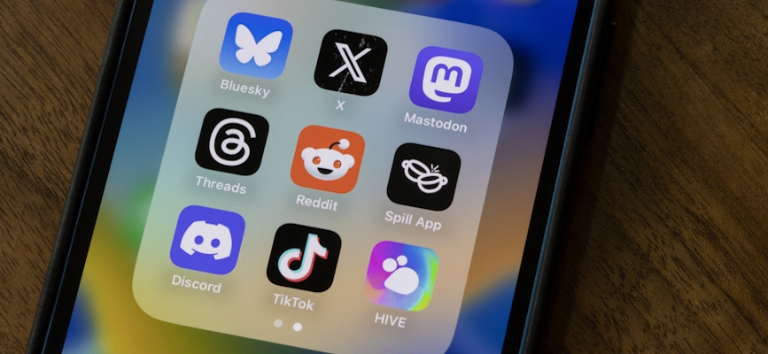 A phone showing icons of social platforms including Bluesky, Twitter, and Mastodon to illustrate a story about social platforms news influecners prefer