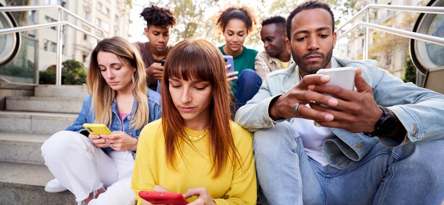 -young people seriously looking at phones to show Gen Z news engagement-