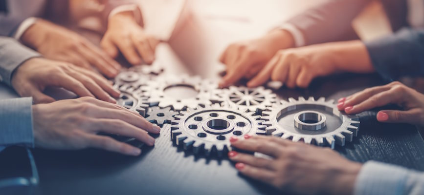 -hands working together to align cogs to represent publishers negotiating AI licensing together-