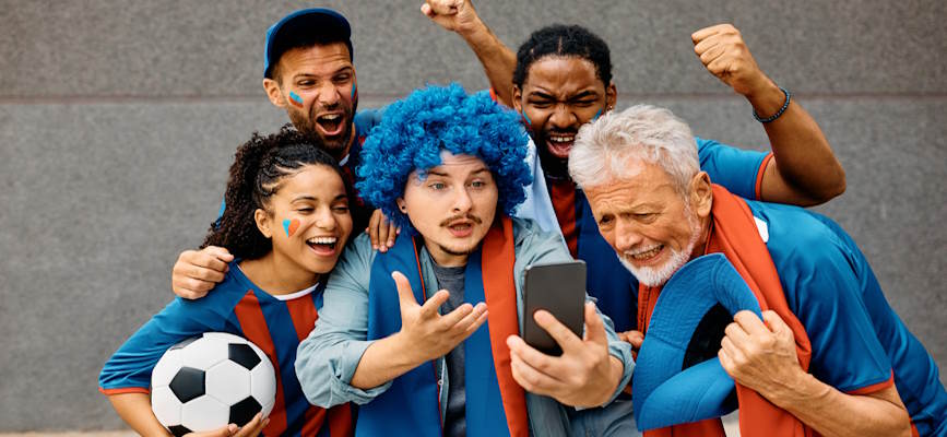 -a group of sports fans cheering the game streaming on a phone-
